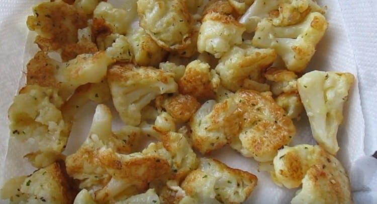 We transfer the fried inflorescences to paper towels.