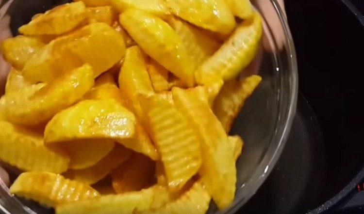 We take out the potatoes from the cauldron, drain the oil.