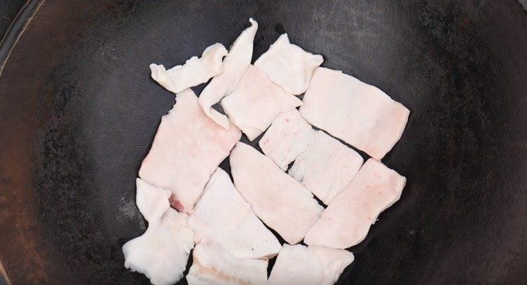 At the bottom of the cauldron, lay out a thick layer of sliced ​​fat.