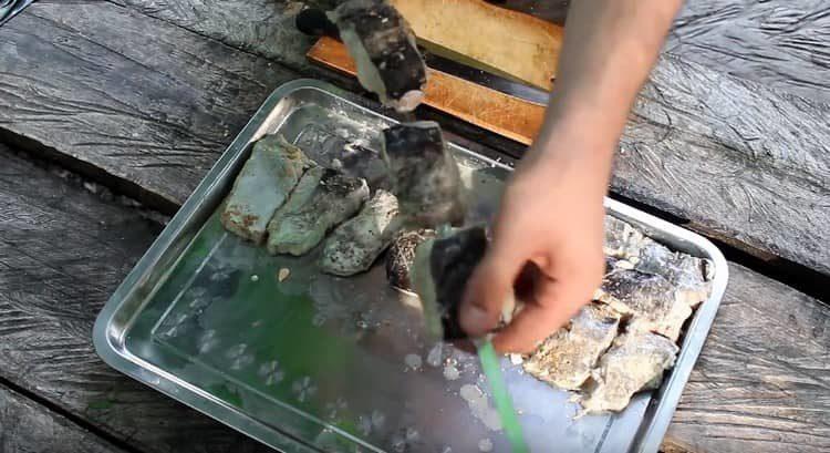 String pieces of catfish on a skewer.