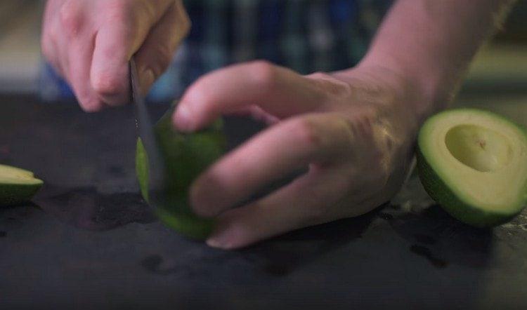 Cut the top in an avocado so that the fruit stays steady on the baking sheet.