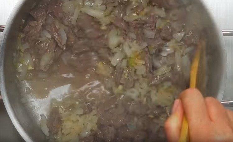 Add the onions and garlic to the meat.