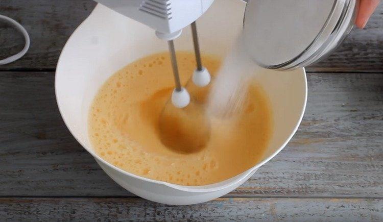Slowly add sugar to the egg mass.