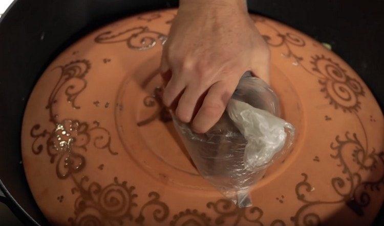 cover the cauldron with a large plate. put the load on top.