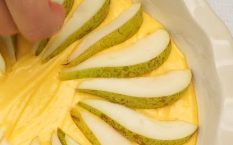 On top of the dough, beautifully lay the slices of pears.