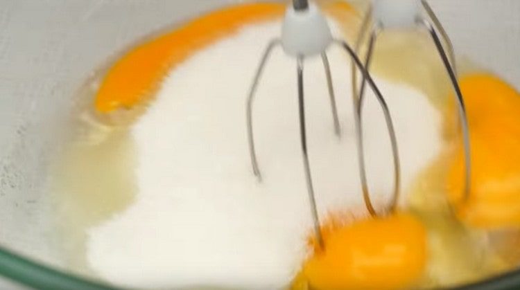 Beat eggs with sugar using a mixer.