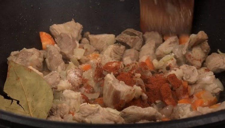 Add bay leaf and paprika to the meat.