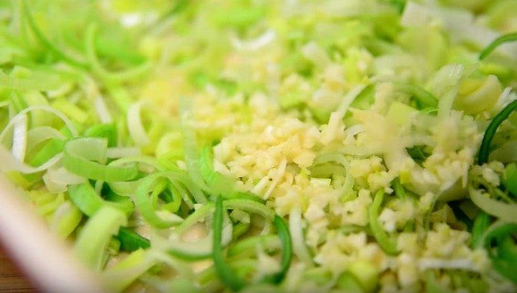 pour leek, garlic on the bottom of the greased form with butter and mix them.