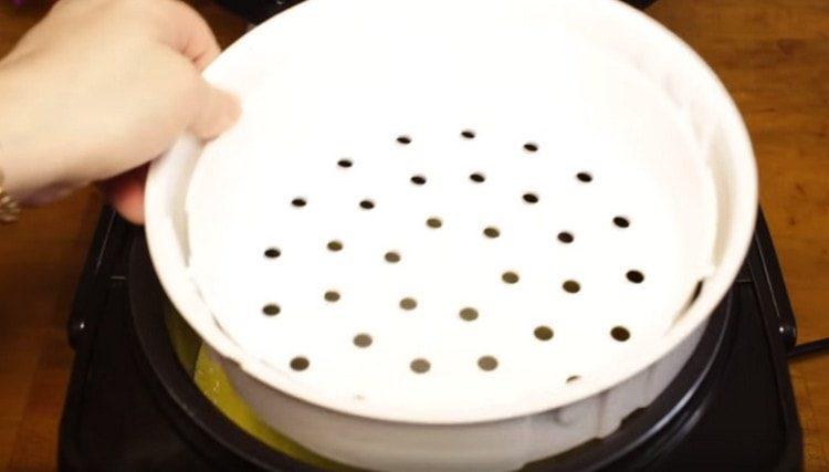 Pour the vegetable mass into the multicooker and set the basket for steaming on top.