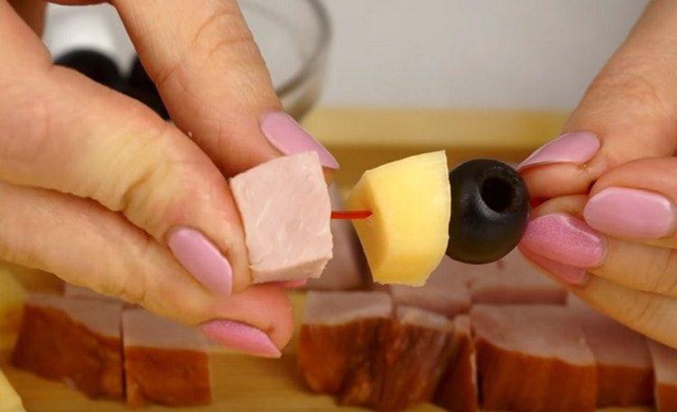 We put olive, cheese and a slice of ham on a skewer.