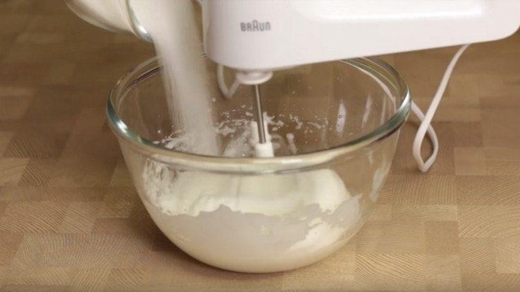 Slowly introduce sugar into the protein mass.