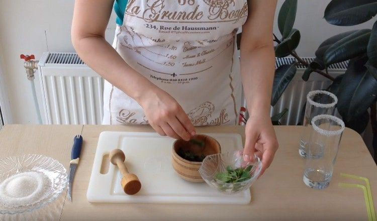 In the mortar, spread the washed leaves of mint.