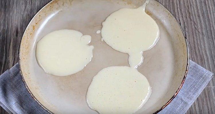 Pour dough into portions in a preheated pan.
