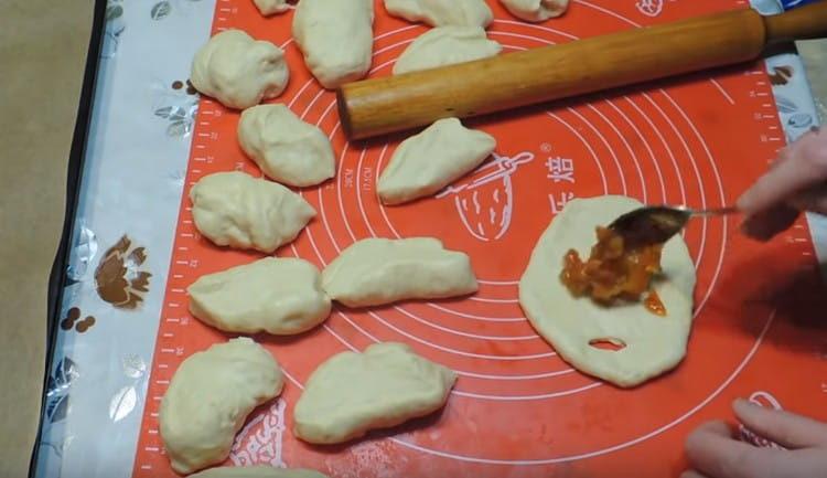 stretch portions of the dough into flat cakes, make an incision on one side of the flat cakes.