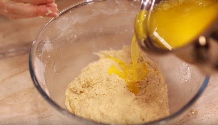 Gradually add melted butter to the dough.