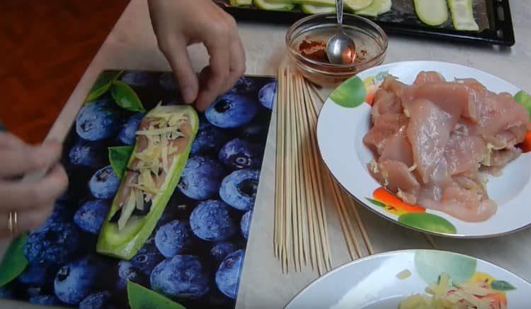 We spread chicken, basil, cheese on a slice of zucchini.