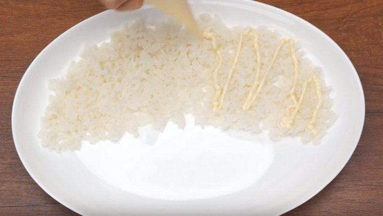 Spread rice with the first layer of salad, grease with mayonnaise.