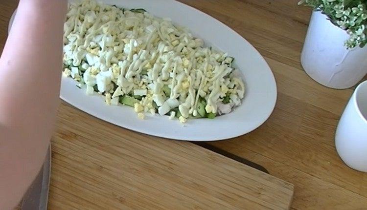 then we make a layer of grated eggs, mayonnaise.