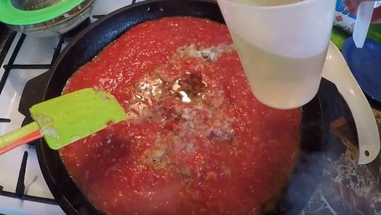 Add tomato mass to the onion, as well as vegetable oil.