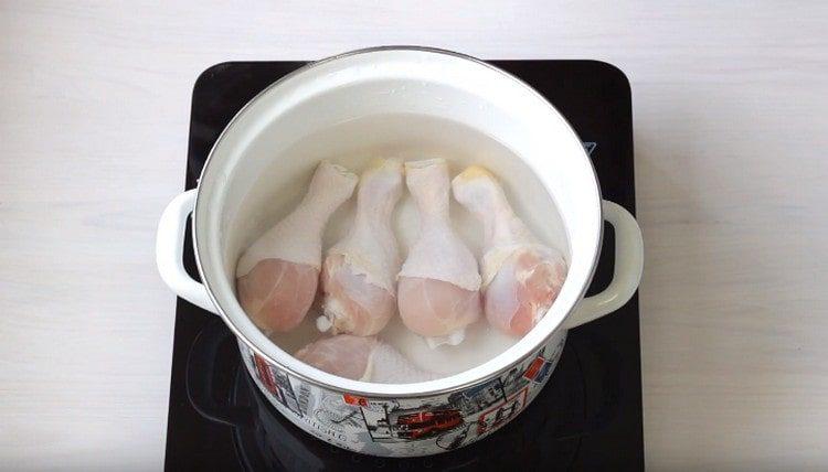 We spread the chicken drumsticks in the pan, fill them with water.
