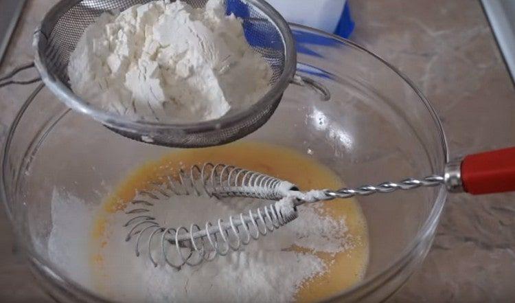 Sift flour into the egg mass.