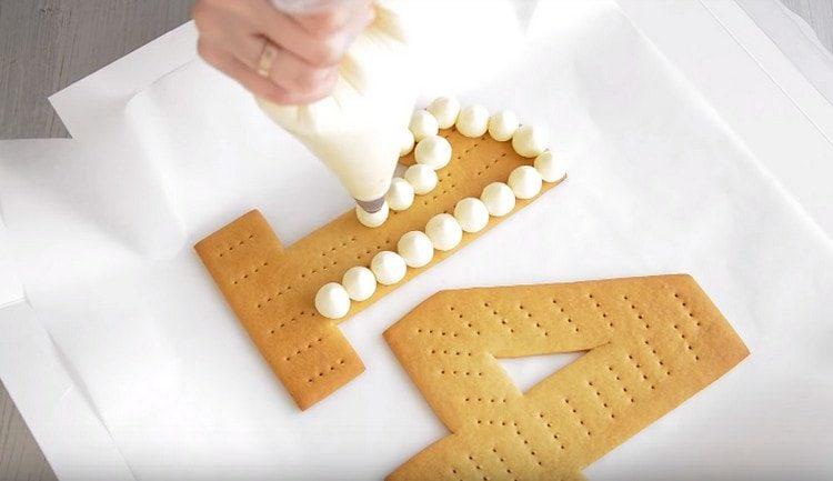 Using a pastry bag, cover the first couple of numbers with drops of cream.