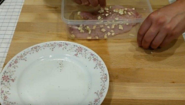 Spread turkey meat in a food container, sprinkle with garlic