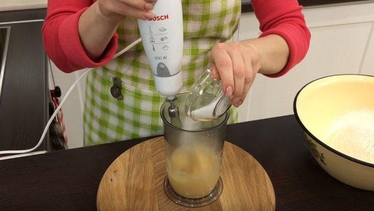 Beat the eggs, adding sugar to them.