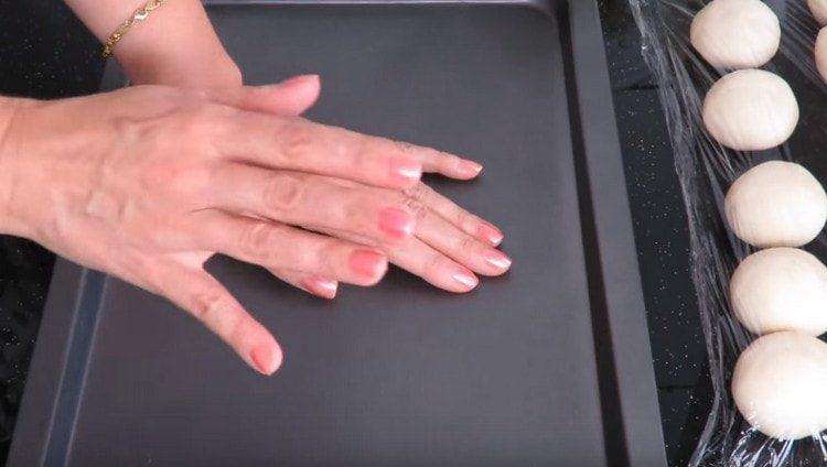 Grease a tray for future flat cakes with vegetable oil.