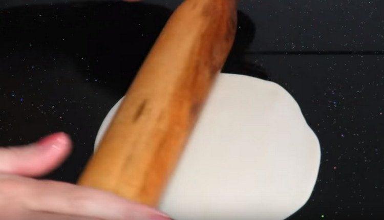 On a greased surface with vegetable oil, roll out portioned dough pieces.