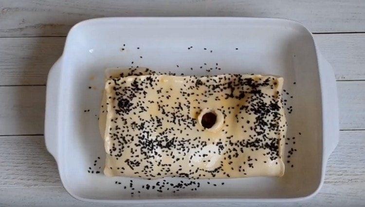 In the center of the workpiece we make a hole for steam to escape, you can also grease the dough with yolk and sprinkle with sesame seeds.