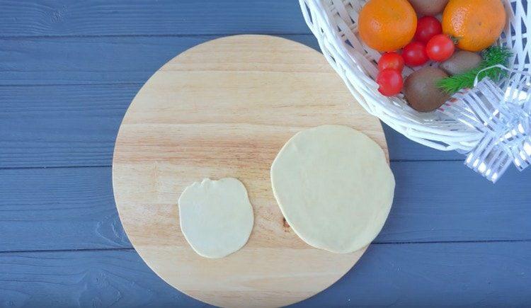 We roll out a larger and a smaller piece into flat cakes.